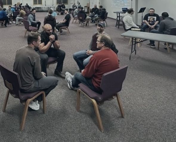 Summit men in small group circles, talking in a church hall